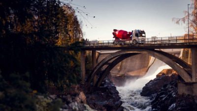 Der Volvo FMX fährt auf einer Brücke über einen Fluss