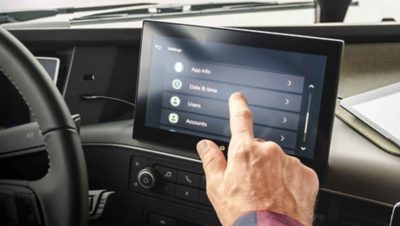 Un conducteur est assis dans la cabine et utilise le nouvel écran secondaire tactile
