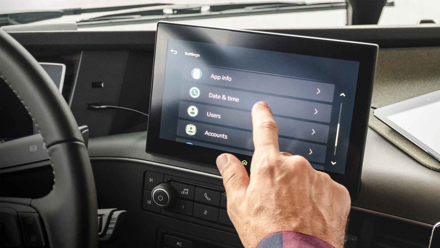 Motorista sentado na cabina a utilizar o novo display lateral com ecrã tátil