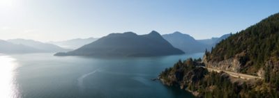 Aerial panoramic view of the Sea to Sky Highway in Howe Sound, North of Vancouver, British Columbia, Canada. Taken during a sunny summer day.