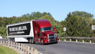 Red Mack truck with the message "I'm one in a million" on its payload on a road in Allentown, USA