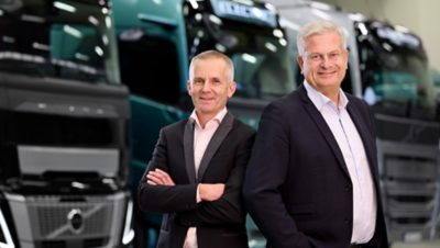 A képen Mattias Ahlberg és Tomas Thuresson áll egymás mellett, hátuk mögött az új teherautókkal