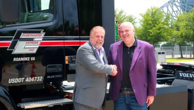 Mayor Jim Ross, City of Arlington, Texas, congratulates Travis Smith, chief operating officer of Fleetmaster Express on deploying the first commercial Class 8 battery-electric trucks in Texas.