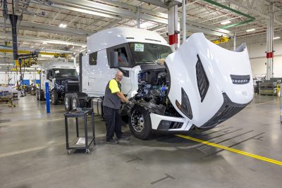 Truck with its hood open with a technician at Volvo’s New River Valley facility in Virginia working on the new Volvo VNL Autonomous truck platform