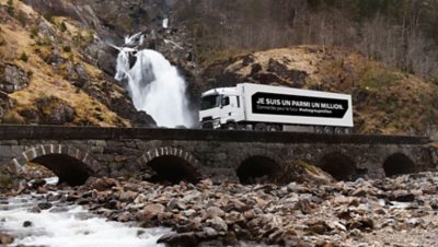 White Renault truck with the message "I'm one in a million" on its payload, driving on a bridge in Lyon, France