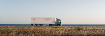 Volvo-Lkw fährt vor dem Meer im Hintergrund