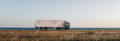 Volvo-vrachtwagenchauffeur met de oceaan op de achtergrond