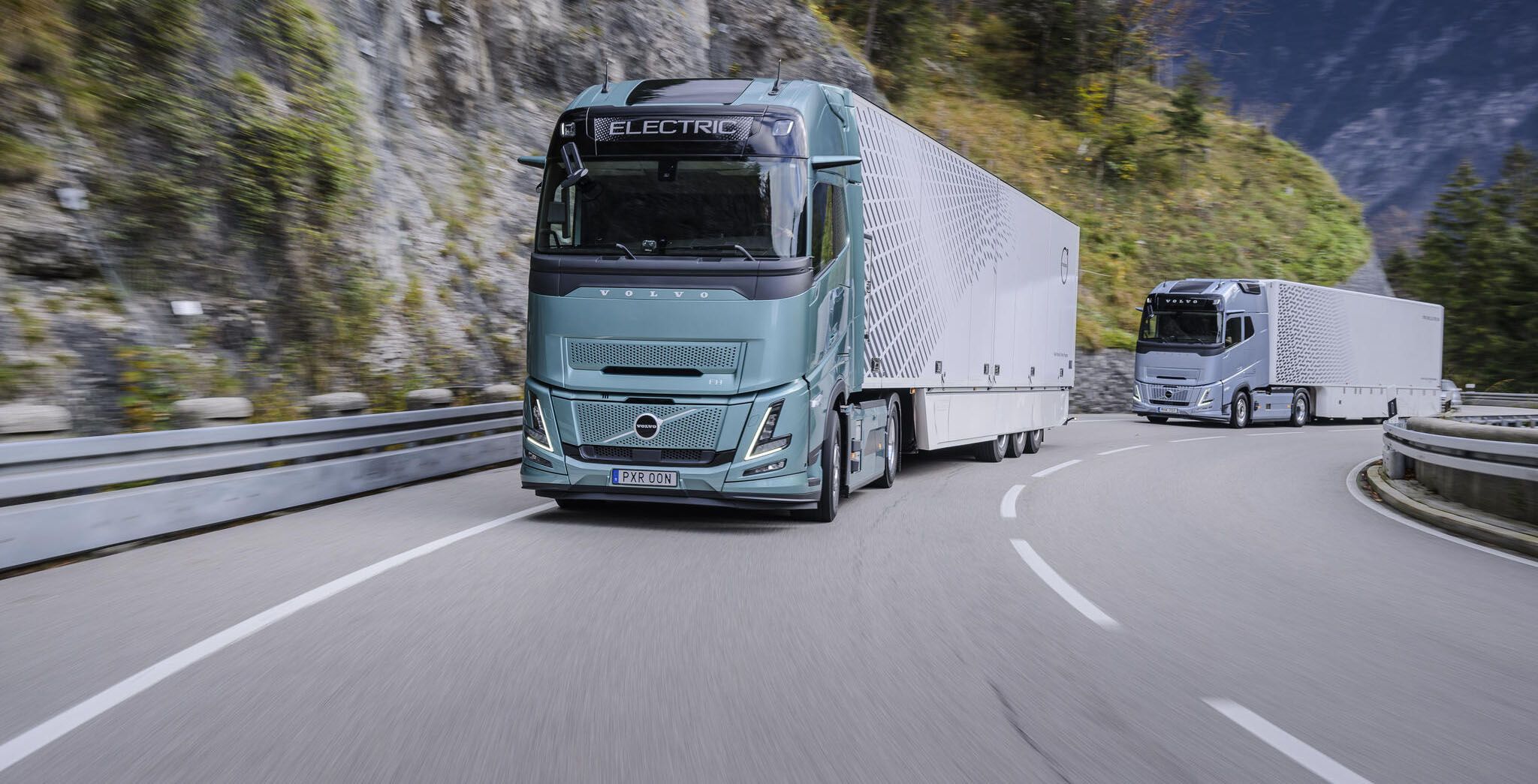 Dva električna Volvo kamiona voze se planinskom cestom.