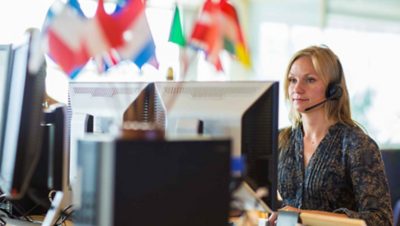 A woman with a headpiece sitting in front of a screen at the Volvo Trucks International Uptime Center