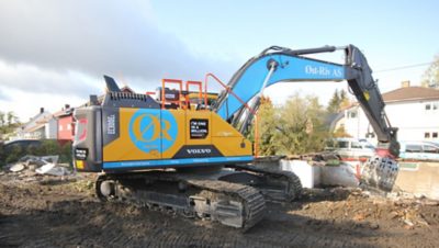 Blue and yellow Volvo excavator at a construction site in Oslo, Norway