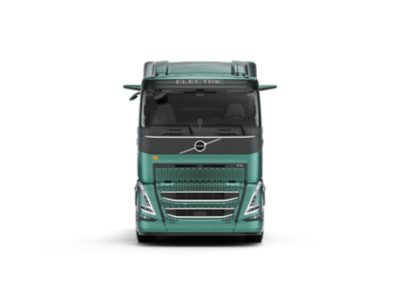 Студийная фотография грузового автомобиля Volvo FH Electric (вид спереди). На фото видна бирюзовая кабина, аэродинамическая решетка и маркировка «ELECTRIC» над лобовым стеклом.
