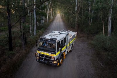 Volvo fire truck drives along the road at the edge of a forest