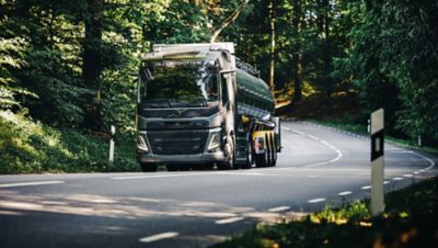 Volvo FM กำลังขับอยู่บนทางโค้งในป่า