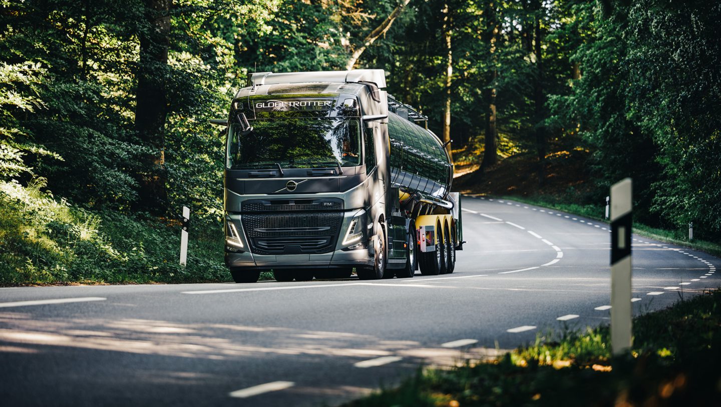 Volvo FM fährt auf einer kurvigen Strasse im Wald