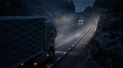  Self driving Volvo truck driving on a road at night, meeting a Volvo car in the opposite car lane.