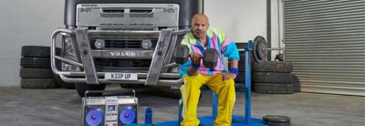 Man lifting weight in front of Volvo Truck