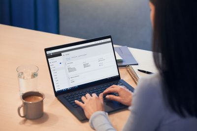 Mujer trabajando con ordenador con Volvo Connect en pantalla.