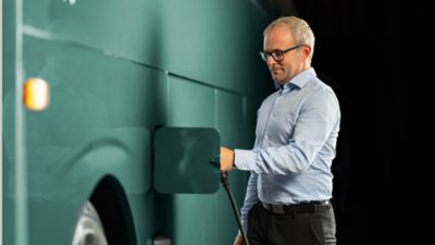 Chauffeur d'autocar branchant le chargeur sur un autocar électrique Volvo