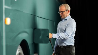 Bus driver plugging the charger into an electric Volvo coach
