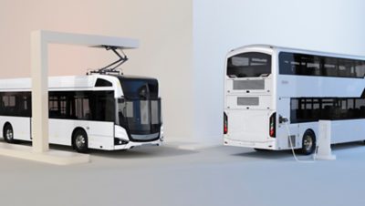 Two Volvo BZL Electric, one double-decker with a charging cable connected, and one single-decker, charging under an OppCharge pantograph.