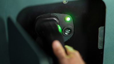 Close-up of a charging plug being connected to an electric Volvo coach