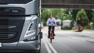 Volvo FM 的特寫，背景右側有一輛自行車