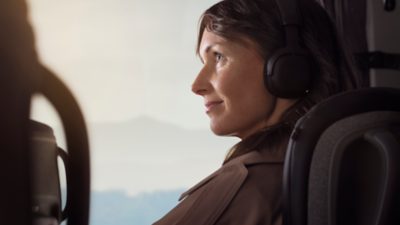 Image of a passenger in a bus seat, wearing headphones 