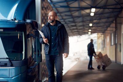 Driver walking beside truck with clipboard