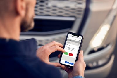 Mann arbeitet am Mobiltelefon mit Volvo Connect