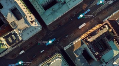 A birds view of a city street with two buses, with graphics and text visualising connectivity.
