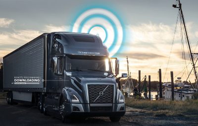Dark truck driving next to a small port with the text “downloading” next to it | CampX - Startup Accelerator by Volvo Group