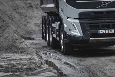 A Volvo FMX drives through the mud