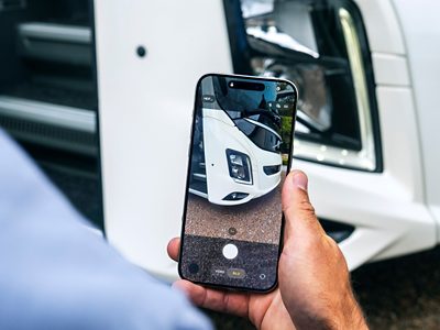 A bus driver's point of view taking a picture of a headlamps unit when using the Daily Inspection service