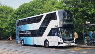 A Volvo BZL Electric double-decker driving down a street