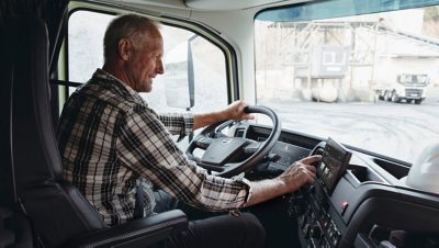 Volvo truck driver checking the Volvo Driver guide in the built in screen in his truck