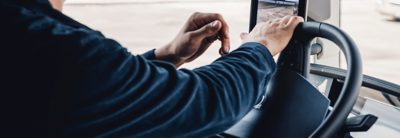 Closeup of hands on a black steering wheel