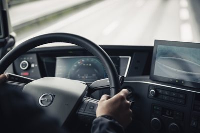 Closeup of hands on a black steering wheel