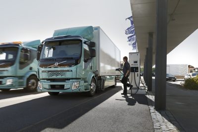 Um motorista carrega o seu camião elétrico