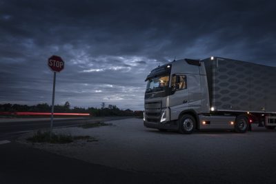 Un camión estacionado de noche con las luces interiores encendidas.