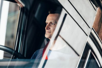 Driver in cab, looking out the window smiling