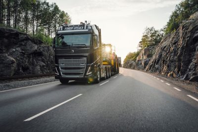 A Volvo FH16 drives around a curve between rocks