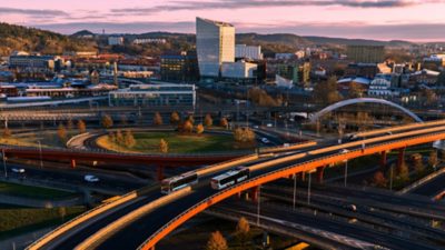 Electric city and intercity buses crossing on an access road bridge