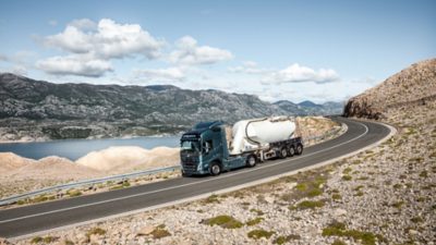 A truck drives down a curving slope