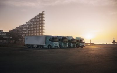Des camions électriques Volvo alignés au coucher du soleil.