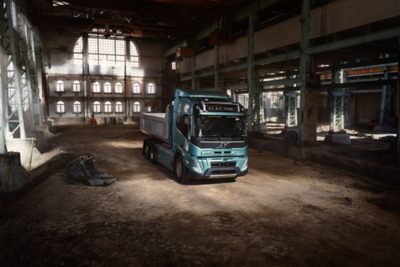 Rectangular high‑voltage electrical power distribution unit shown in a clean studio setting, featuring multiple orange high‑voltage connectors on the side and a warning symbol on the front panel. The black housing and mounting points are clearly visible against a plain light background.