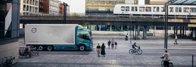 Volvo FM rijdt in de stad, vlakbij spoorweg