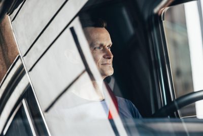 Vodič v kabíne hľadí s úsmevom z okna