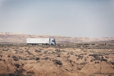 Model Volvo FH Aero jazdí po ceste v oblasti s horami, pohľad z boku