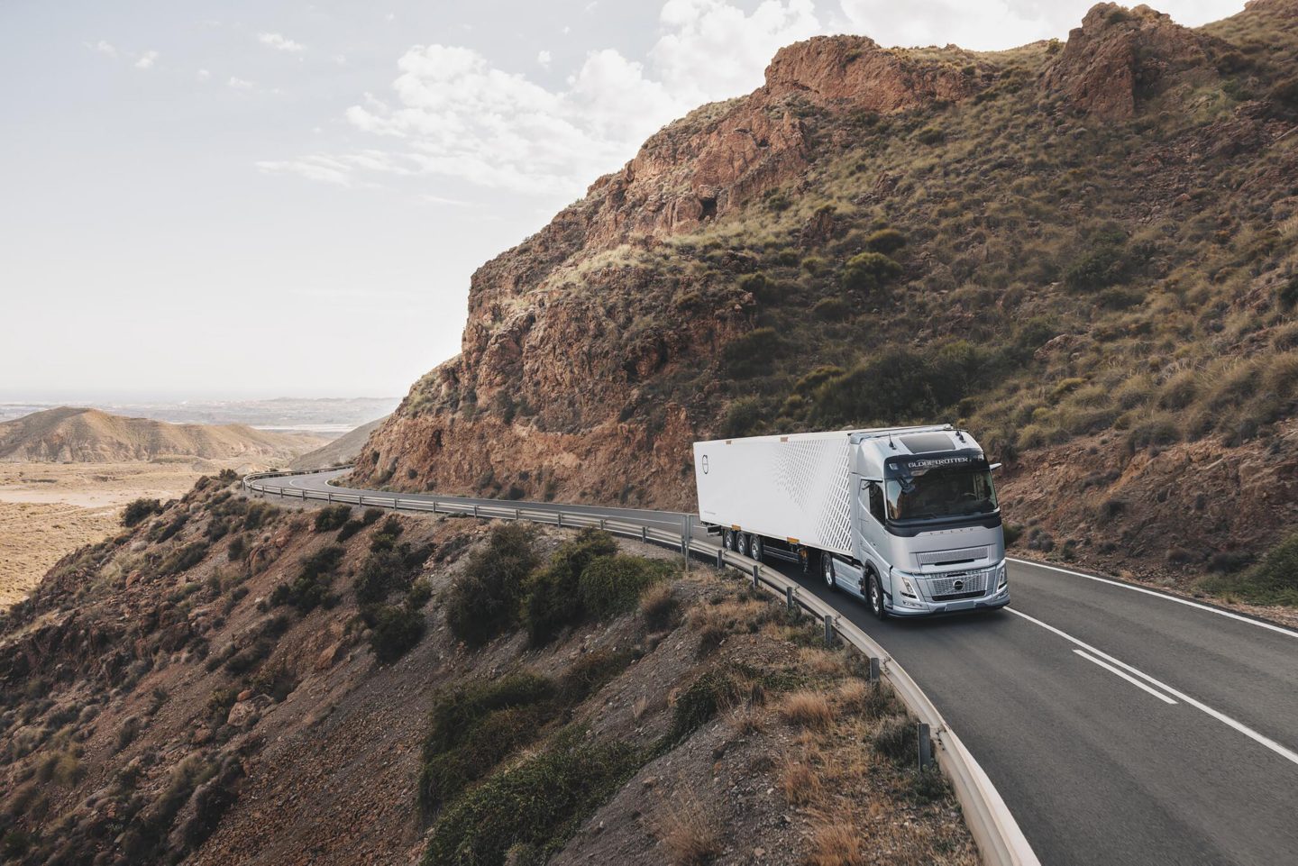 Pohled zepředu z boku na model Volvo FH Aero jedoucí po silnici