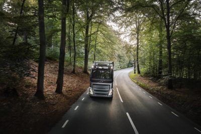 Volvo FH jazdiace po ceste v lesnej oblasti